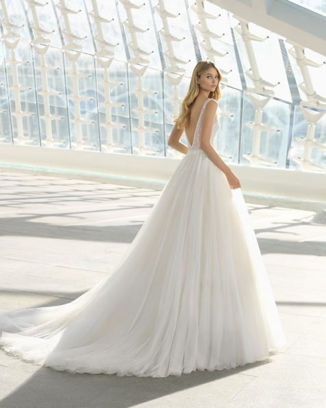 Vestido de novia estilo princesa en tul y pedrería. Escote deep-plunge y falda con aplicaciones de pedrería. Disponible en color marfil y natural. Colección ROSA CLARA 2019.