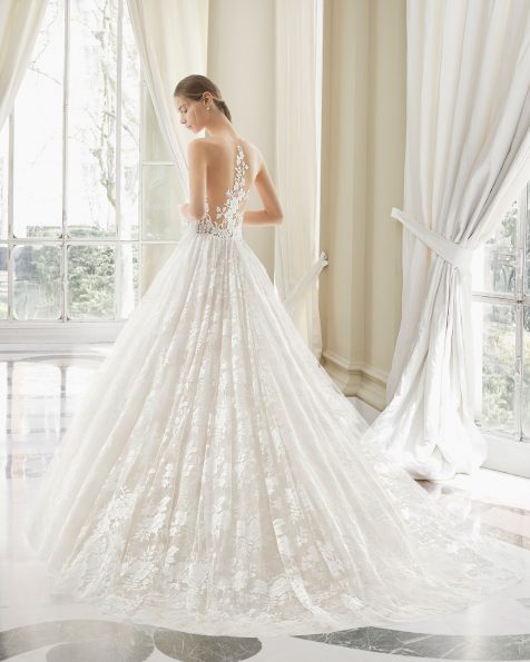 Robe de mariée style princesse en dentelle avec pierreries et tulle royal. Décolleté plongeant et décolleté dans le dos. Avec transparences et mancherons. Disponible en couleur naturelle/nude et naturelle. Collection ROSA CLARA COUTURE 2019.