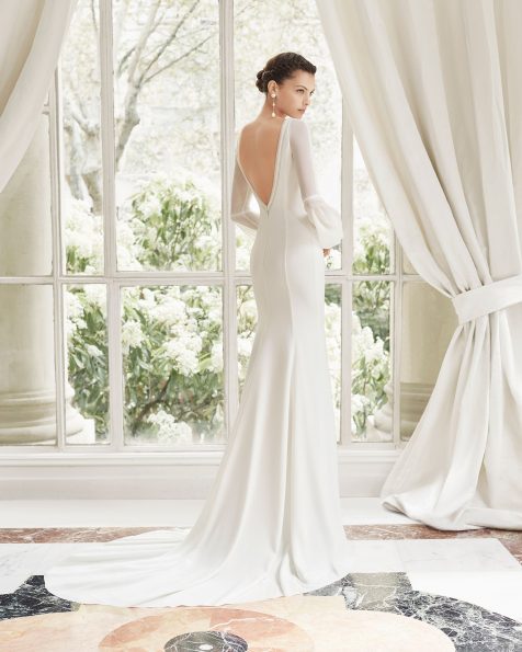 Vestido de noiva corte reto de crepe. Decote deep-plunge, costas em V e manga comprida de crepe georgete. Com abertura frontal, adorno com trabalhado de ponto bordado e passamanaria. Disponível em cor natural. Coleção ROSA CLARA COUTURE 2019.