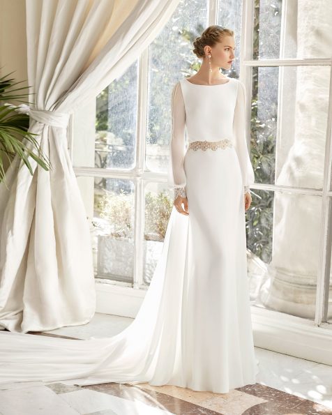 Vestido de novia estilo boho en georgette y guipur. Escote barco, espalda escotada y manga larga. Con transparencias, adorno de vainica y cola extraible en georgette. Disponible en color natural. Colección ROSA CLARA COUTURE 2019.