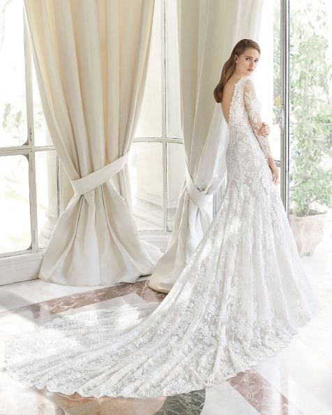 Abito da sposa dal taglio sirena di pizzo con applicazioni in guipure. Scollo profondo e schiena a V. Con trasparenze. Disponibile in colore naturale. Collezione ROSA CLARA COUTURE 2019.