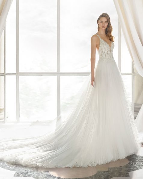 Princess-Brautkleid aus strassbesetzter Spitze und Royal-Tüll. Deep-Plunge-Ausschnitt und transparente Einsätze. Mit Culotte und bauschigem Rock mit Vorderschlitz. Erhältlich in Naturweiß. Kollektion ROSA CLARA COUTURE 2019.