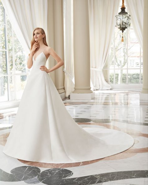 A-line amalfi brocade wedding dress. With sweetheart neckline, low back and spaghetti shoulder straps. Lace jacket with long sleeves, jewel neckline and closed back. With insert. Available in natural. 2019 ROSA CLARA COUTURE Collection.