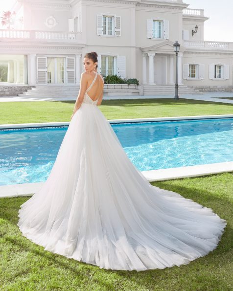 Vestido y sobrefalda de novia estilo línea A de tul y encaje pedrería. Escote halter y espalda con abertura redonda. Colección ROSA CLARA 2020.