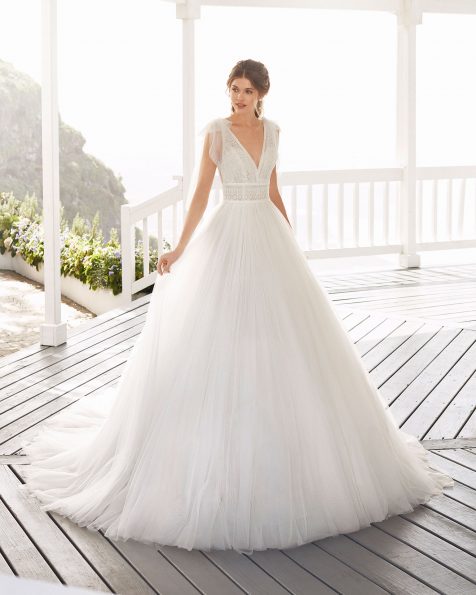 Robe de mariée style trapèze en tulle plumetis et dentelle. Col en V avec tombants en tulle et décolleté dans le dos. Collection ROSA CLARA 2020.