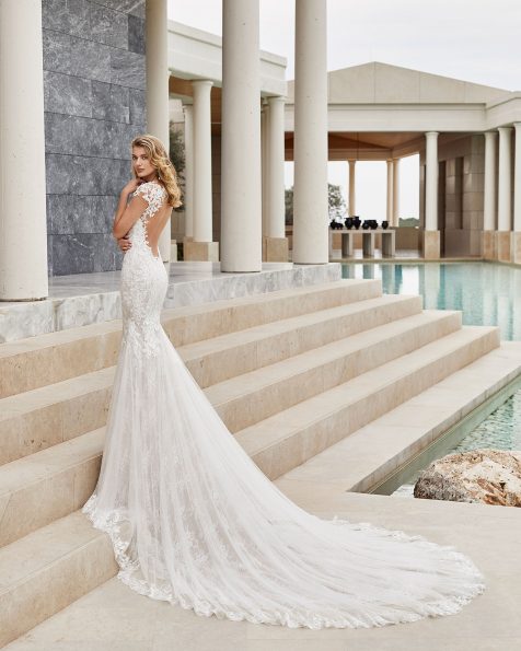 Robe de mariée style sirène en dentelle avec applications de guipure avec pierreries. Col illusion avec forme cœur et décolleté dans le dos. Avec transparences et applications sur les épaules. Collection ROSA CLARA COUTURE 2020.