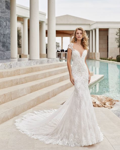Robe de mariée style sirène en dentelle avec applications de guipure avec pierreries. Col illusion avec forme cœur et décolleté dans le dos. Avec transparences et applications sur les épaules. Collection ROSA CLARA COUTURE 2020.
