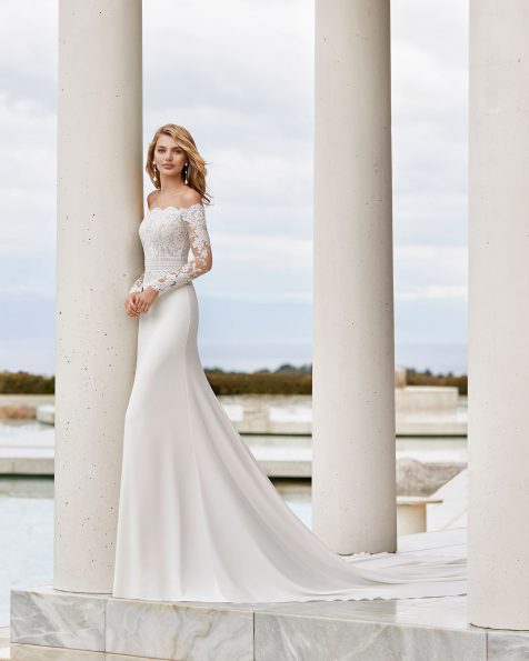 Lightweight wedding dress in lace and crepe. Strapless neckline and long sleeves. With beaded scalloped lace and linear lace detail at the waist. 2020 ROSA CLARA COUTURE Collection.
