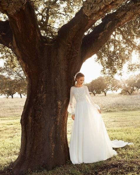 A-Linien-Brautkleid und abnehmbare Schleppe aus Voile mit Spitzenbesatz. Mit hochgeschlossenem Ausschnitt, tief ausgeschnittenem Rücken und langen Ärmeln. Kollektion ROSA_CLARA_BOHEME 2021.