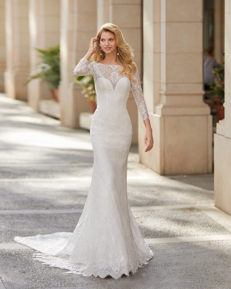 Vestido de novia corte recto de encaje y pedrería en cuerpo, escote cerrado con escote corazón interior y espalda con encaje y manga larga. Colección ROSA CLARA 2021.