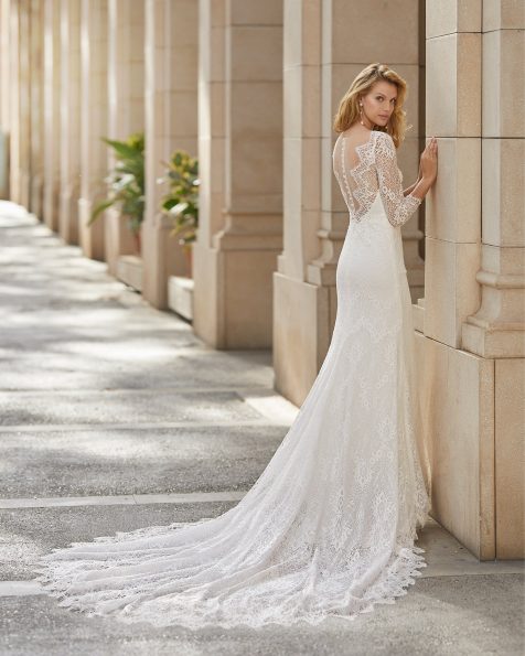 Vestido de novia corte recto de encaje y pedrería en cuerpo, escote cerrado con escote corazón interior y espalda con encaje y manga larga. Colección ROSA CLARA 2021.