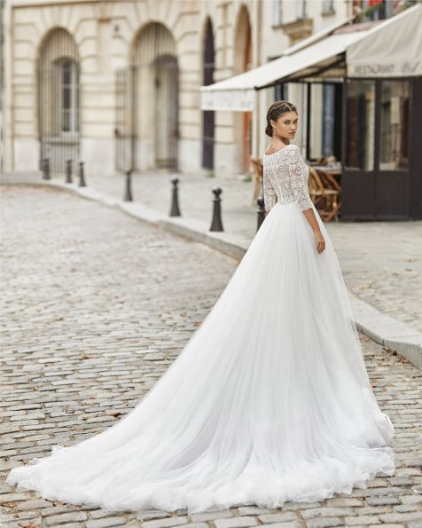 Princess-style wedding dress with skirt in soft tulle, beaded lace bodice and three-quarter sleeves. Bateau neckline with sweetheart underlay and closed back. 2021 ROSA CLARA Collection.