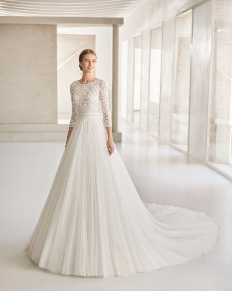Elegant princess wedding dress with pin stitch and guipure embellishments; bateau neckline with plunging back and French sleeves. Rosa Clará Haute Couture tailored design in guipure and plumeti tulle. 2022 ROSA CLARA COUTURE Collection.